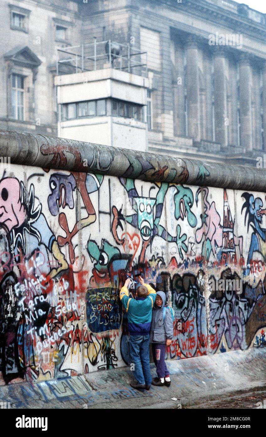 Westdeutsche Kinder versuchen, ein Stück der Berliner Mauer als Souvenir abzuschlagen. Ein Teil der Mauer wurde bereits am Potsdamer Platz abgerissen. Basis: Land Berlin: Deutschland (DEU) Stockfoto