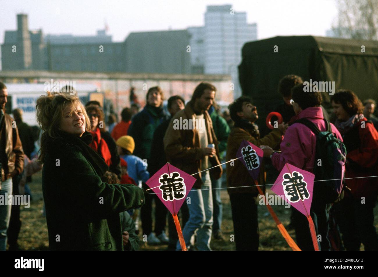 Eine ostdeutsche Frau hält sich an einer Drachenschnur fest, während sie den Abriss eines Teils der Berliner Mauer am Potsdamer Platz feiert. Basis: Berlin Land: Deutschland / Deutschland (DEU) Stockfoto