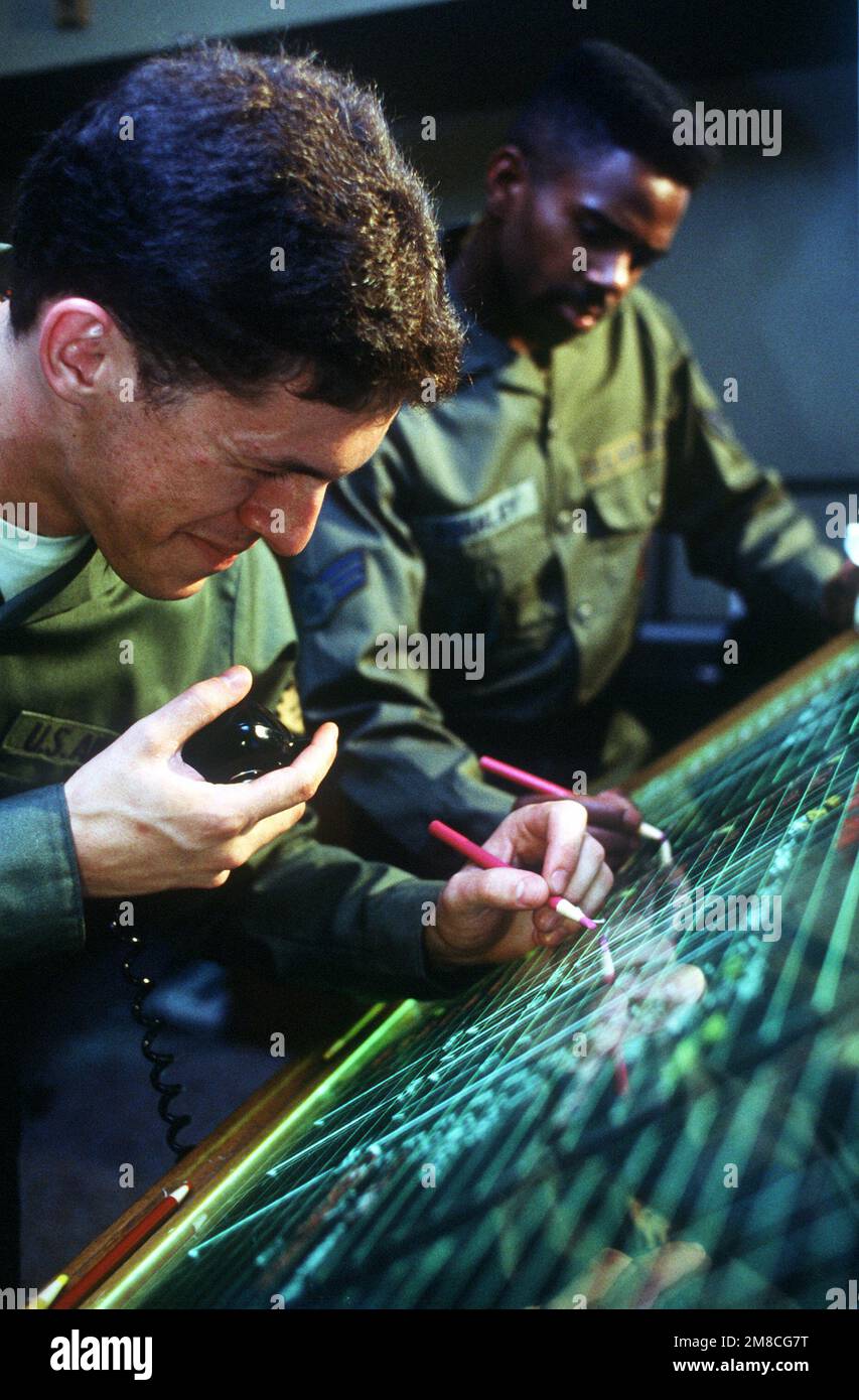 SENIOR AIRMAN Jeff McKee, Left, Waffenkontrolleur des 18. Taktischen Kampfflugflügels, und SGT Gene Hrough Jr. des 432. Taktischen Kampfflugflügels postieren den Status der ankommenden Flugzeuge während des ÜBUNGS-SCOPE-DONNERS 89-5. Betreff Operation/Serie: COPE THUNDER 89-5 Stützpunkt: Clark Luftwaffenstützpunkt Staat: Luzon Land: Philippinen (PHL) Stockfoto
