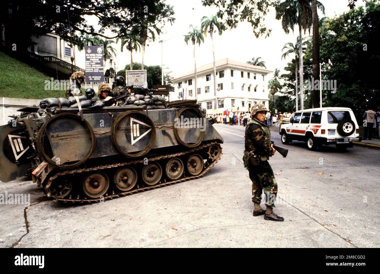 Soldaten einer 5. Infanteriedivision (Mech.) M113 gepanzerte Mitarbeiter bewachen eine Zufahrt zum Gemeindekrankenhauskomplex der Gorgas Army, während panamaische Zivilisten gegen die Entscheidung protestieren, als Reaktion auf die jüngsten Bombendrohungen gegen US-Streitkräfte in Panama Fahrzeuginspektionsstellen einzurichten. Basis: Panama-Stadt Land: Panama (PAN) Stockfoto