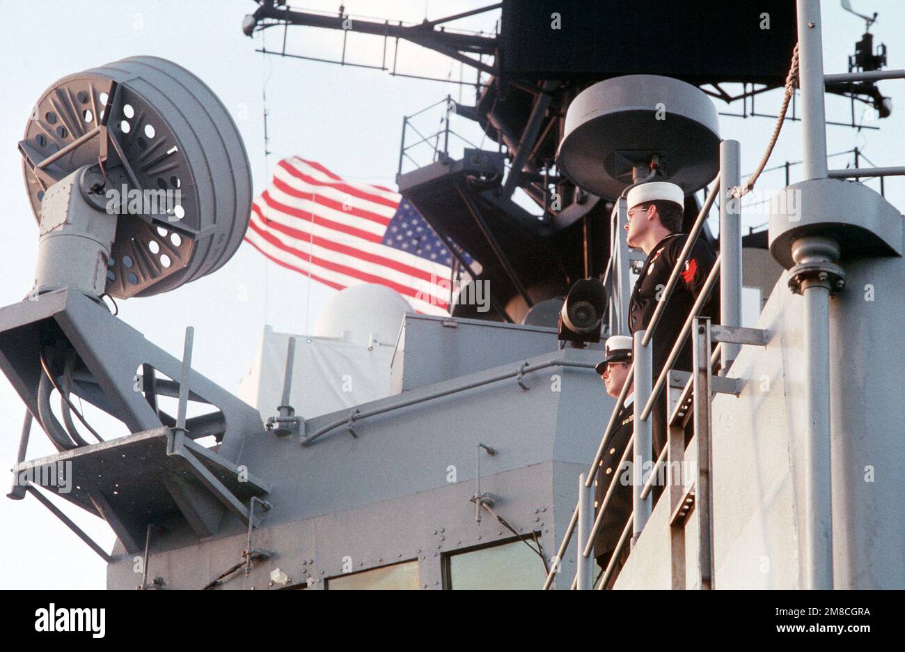 Besatzungsmitglieder bemannt die Schienen während der Probe an Bord des geführten Raketenkreuzers USS BELKNAP (CG 26), dem Flaggschiff der Sechsten Flotte der Vereinigten Staaten. Die Probe findet zur Vorbereitung des Gipfeltreffens zwischen Präsident George H.W. statt Bush und der sowjetische Präsident Michail Gorbatschow werden vom 2. Bis 3. Dezember stattfinden. Basis: Marsaxlokk Bay Country: Malta (MLT) Stockfoto