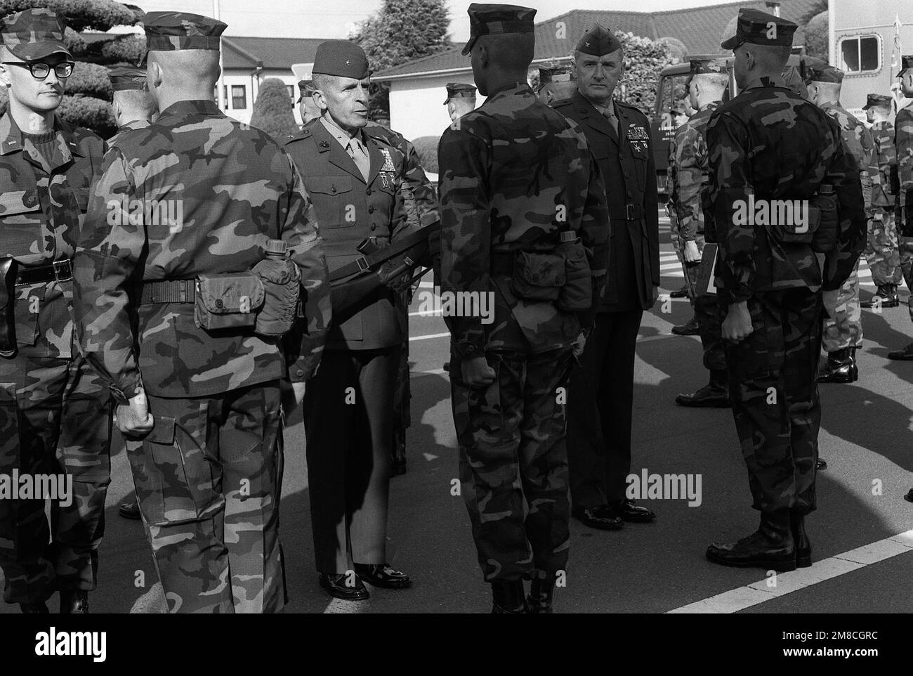 BGEN Robert B. Johnston, Zentrum, STABSCHEF, Marinekorps-Stützpunkte, Japan, Inspiziert das Gewehr eines Marines vom Hauptquartier und vom Hauptquartier, nach dem Bohrteil der Inspektion des kommandierenden Generals der Luftwaffe. Der General wird von 1LT R.G. begleitet Durko, links, Bohrer und OBERST Robert R. Renier, rechts, Befehlshaber der Luftwaffe. Basis: Marine Corps Air Station, Iwakuni Land: Japan (JPN) Stockfoto