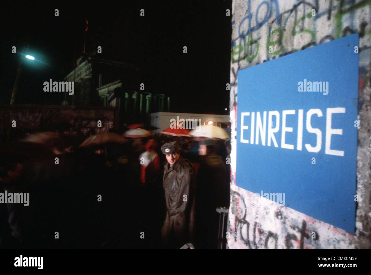 Eine Wache schaut auf den neu geschaffenen Fußgänger, der einen Abschnitt der Berliner Mauer in der Nähe des neu eröffneten Brandenburger Tors durchquert. Basis: Berlin Land: Deutschland / Deutschland (DEU) Stockfoto