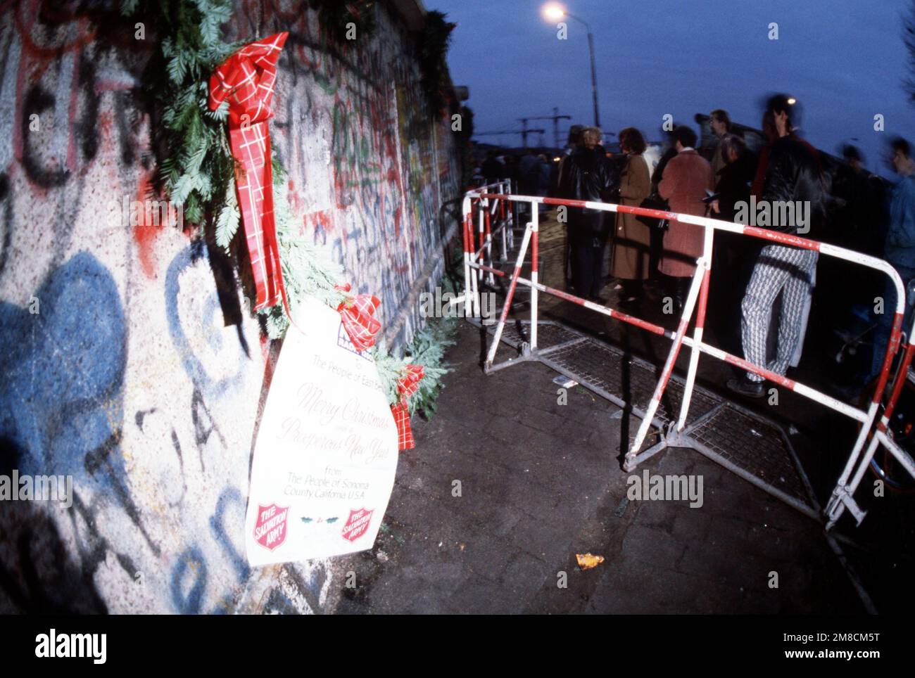 Eine Girlande aus den Vereinigten Staaten überbringt den Menschen in Ostdeutschland Weihnachtsgrüße, während sie die Berliner Mauer in der Nähe des Brandenburger Tors bedeckt. Basis: Berlin Land: Deutschland / Deutschland (DEU) Stockfoto