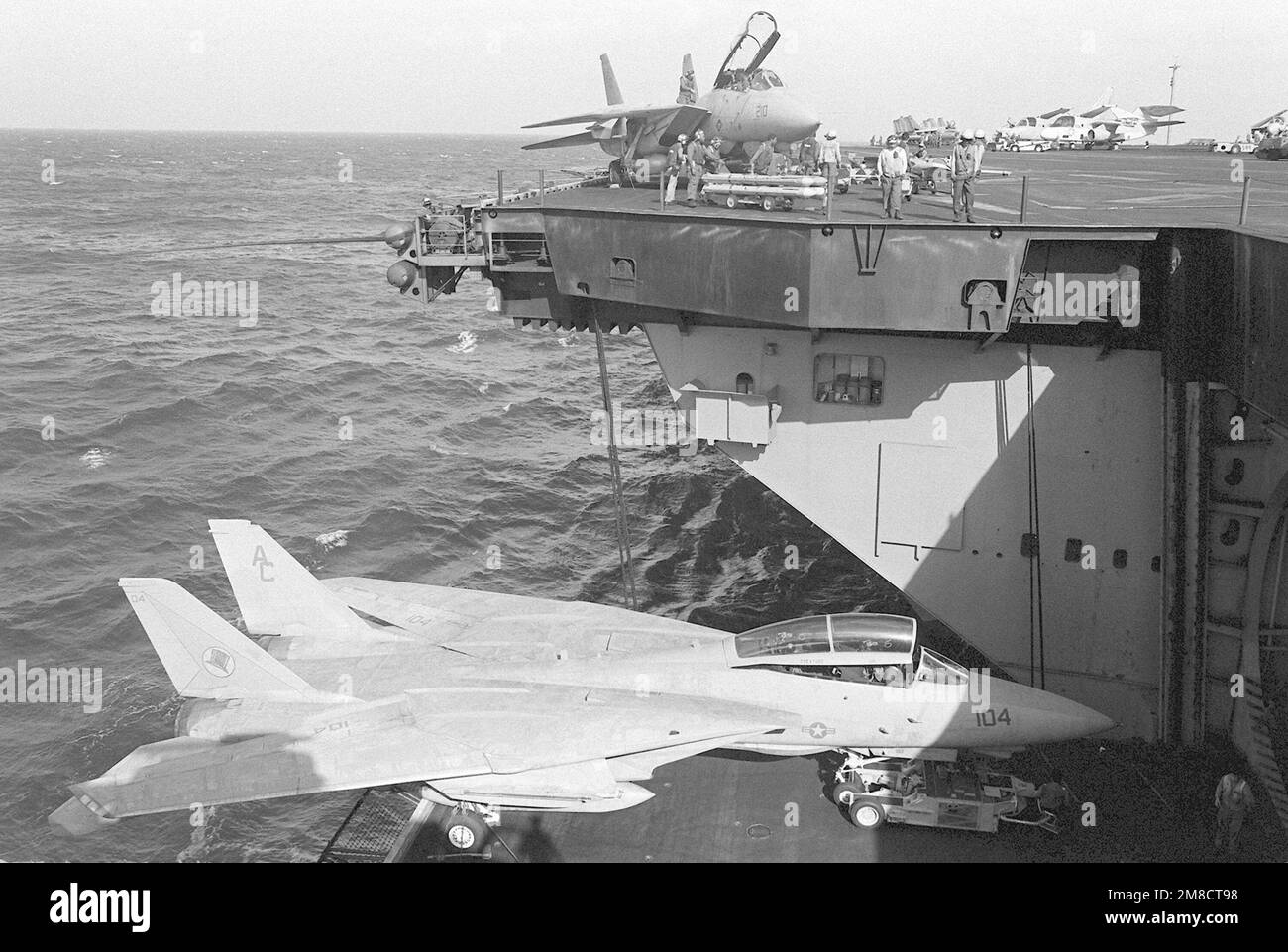 Ein SD-1D-Transportwagen und ein Fighter Squadron 14 (VF-14) F-14A Tomcat-Flugzeug fahren mit einem Aufzug an Bord des Flugzeugträgers USS JOHN F. KENNEDY (CV-67) während DER FLOTTE EX 1-90 zum Hangardeck. Betreff Betrieb/Serie: FLOTTE EX 1-90 Land: Atlantik (AOC) Stockfoto