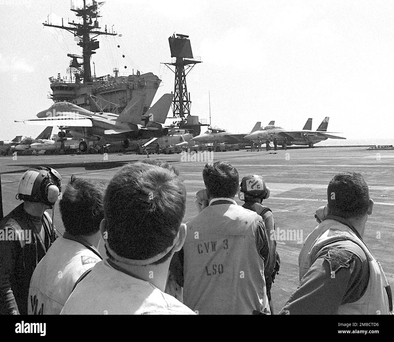 Landesignalbeamte an Bord des Flugzeugträgers USS JOHN F. KENNEDY (CV-67) beobachten, wie ein Kampfgeschwader 32 (VF-32) F-14A Tomcat während DER FLOTTE EX 1-90 eine festgenommene Landung macht. Betreff Betrieb/Serie: FLOTTE EX 1-90 Land: Atlantik (AOC) Stockfoto