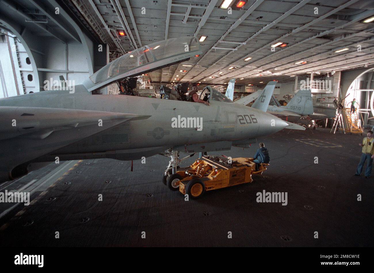 Mitarbeiter des Hangardecks verwenden einen SD-1D-Spürhund, um ein Kampfgeschwader 142 (VF-142) F-14A Tomcat aus einem Aufzug an Bord des nuklearbetriebenen Flugzeugträgers USS DWIGHT D. EISENHOWER (CVN 69) während DER FLOTTE EX '90 zu transportieren. Betreff Betrieb/Serie: FLEET EX '90 Basis: USS Dwight D Eisenhower (CVN 69) Land: Atlantik (AOC) Stockfoto