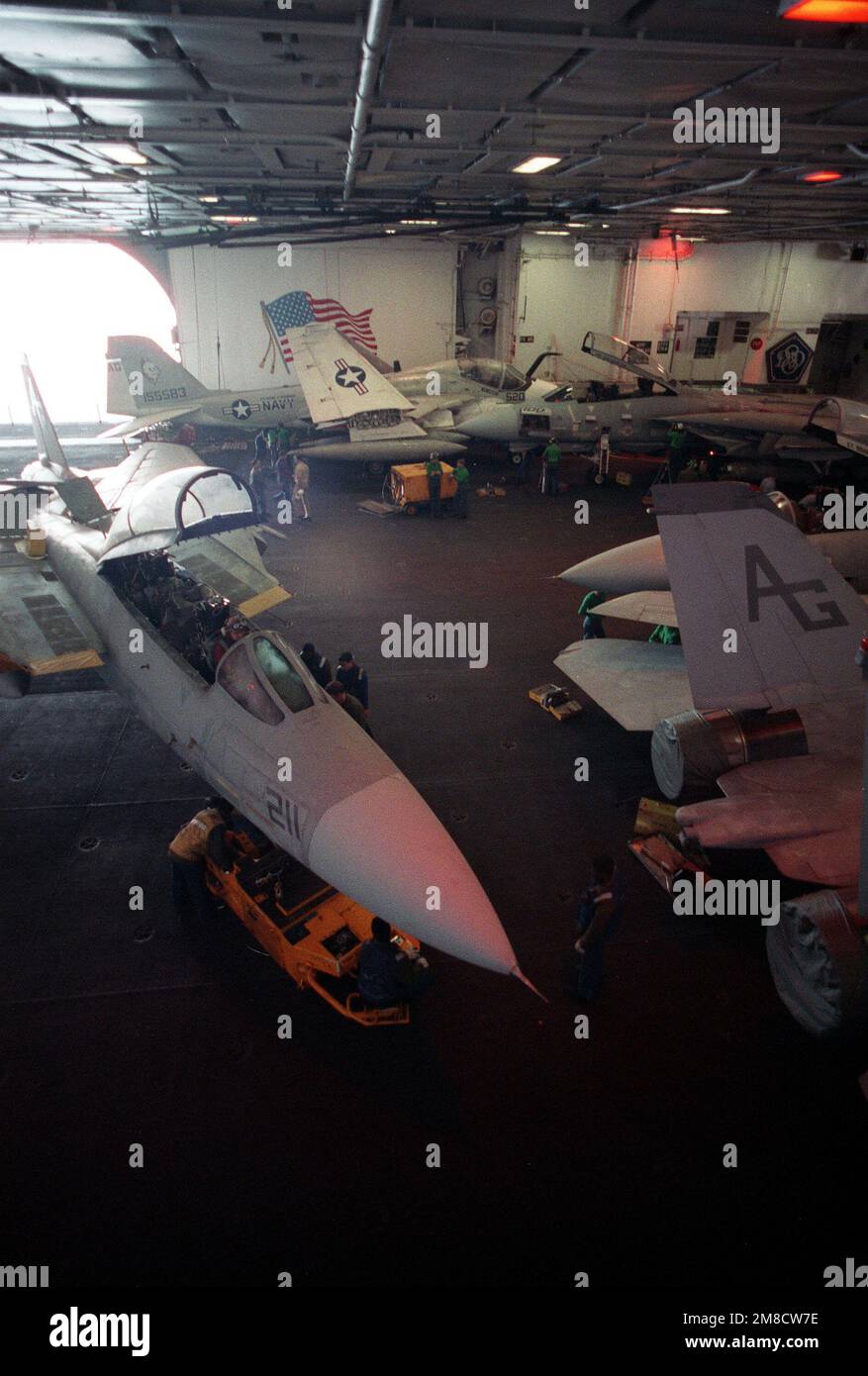 Das Personal am Hangar Deck verwendet einen SD-1D-Spürhund, um ein Kampfgeschwader 142 (VF-142) F-14A Tomcat an Bord des nuklearbetriebenen Flugzeugträgers USS DWIGHT D. EISENHOWER (CVN-69) während DER FLOTTE EX '90 zu transportieren. Gegenstand Betrieb/Serie: FLOTTE EX '90 Land: Karibik Stockfoto
