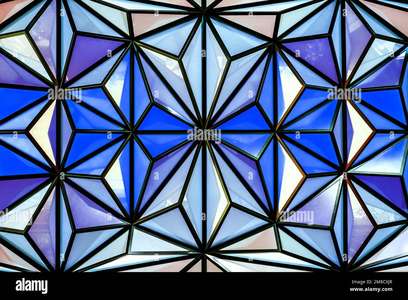 Geometrische Buntglaselemente in Blautönen. Facettiertes Oberlicht aus Dreiecken. Stockfoto