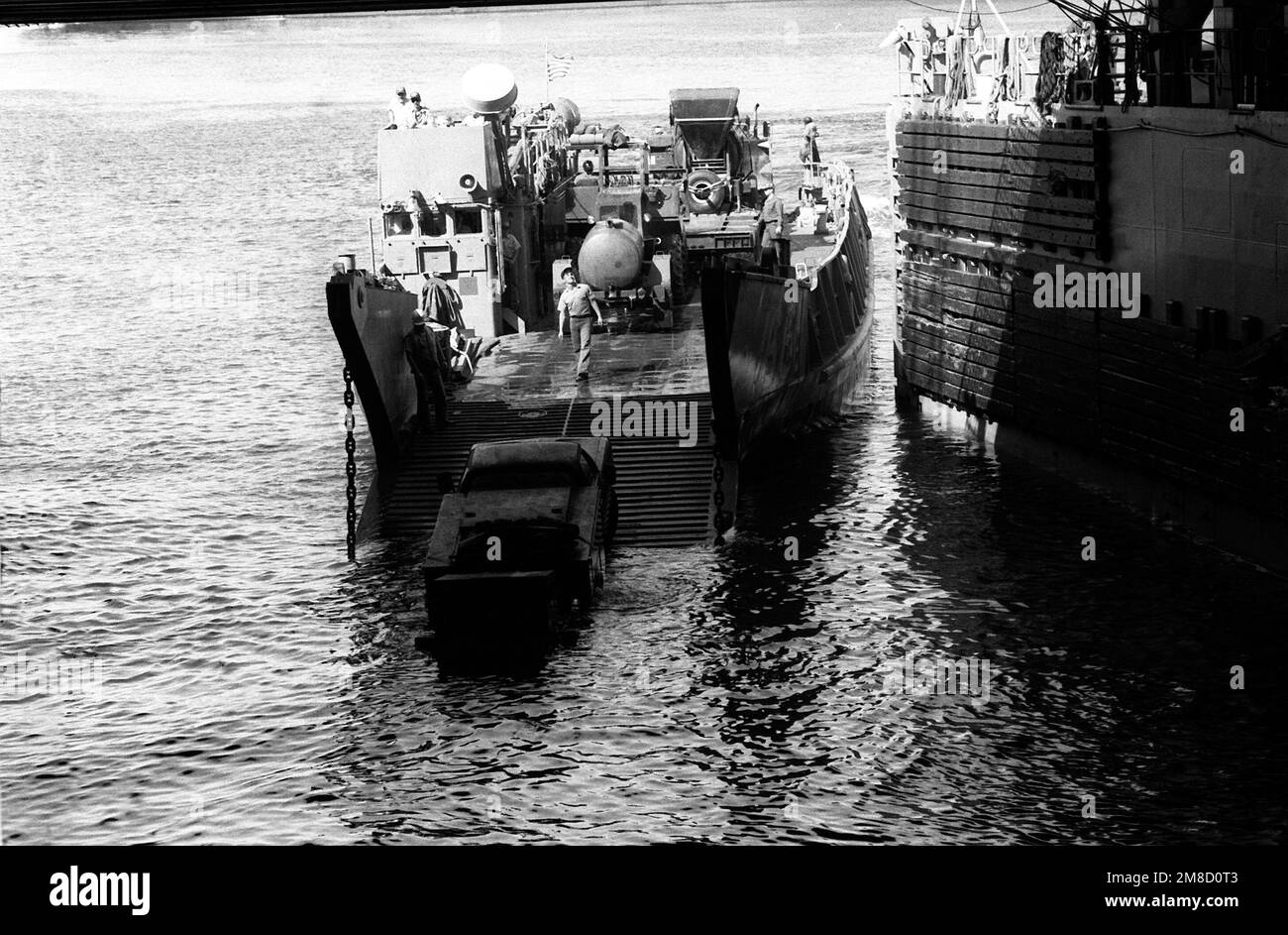 Die Ausrüstung wird von einem Angriffsflugzeug der Einheit 2 (ACU 2) entladen, das sich am Heck des Dock-Landungsschiffs USS PORTLAND (LSD 37) befindet. Die Ausrüstung wird während der Bauübung für die Seabee ATLAS RAIL verwendet, einem Seabee-Projekt zur Reparatur einer durch Hochwasser beschädigten Eisenbahnstrecke. Betreff Betrieb/Serie: EISENBAHNLAND ATLAS: Tunesien (tun) Stockfoto
