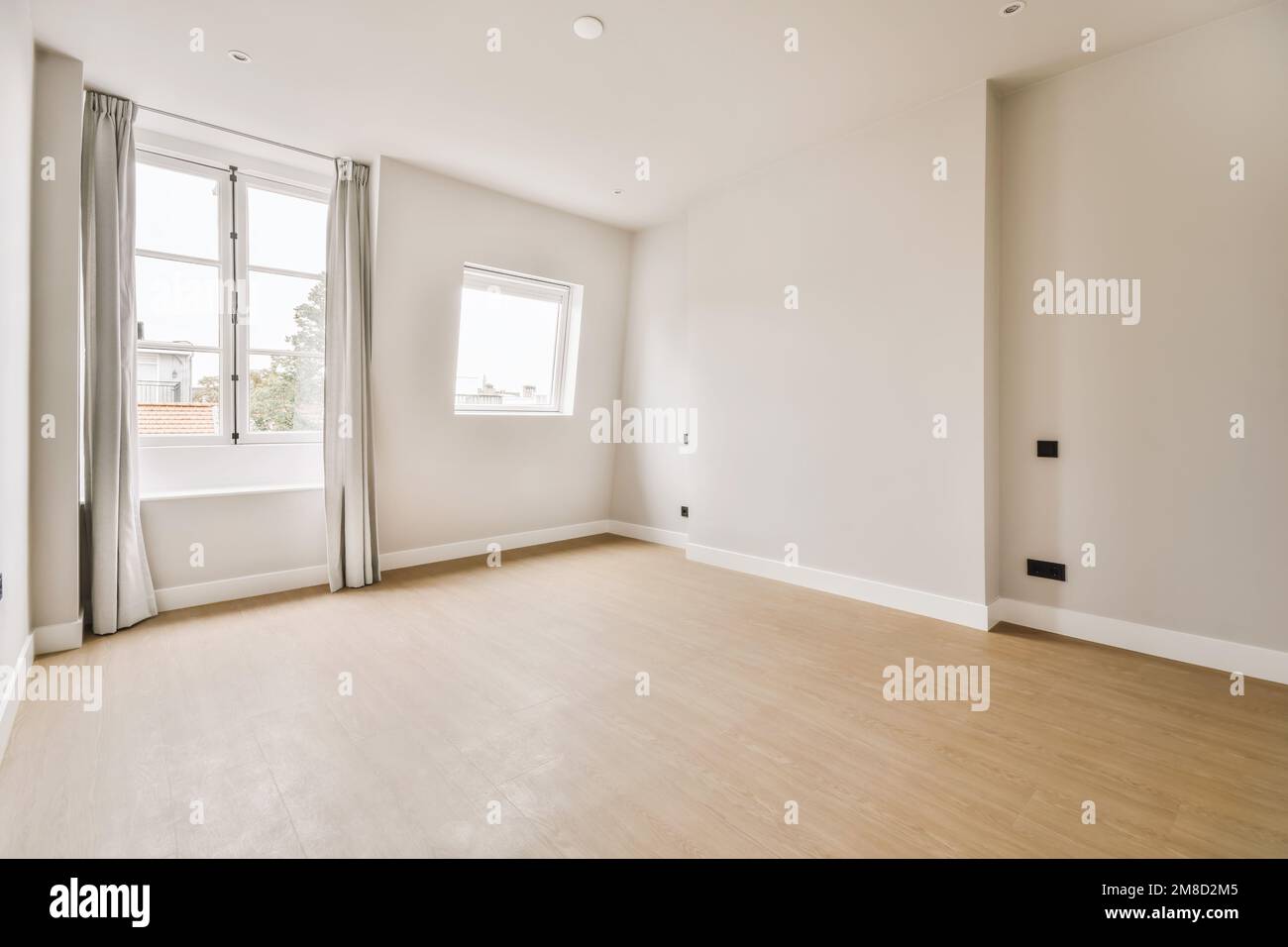 Ein leeres Wohnzimmer mit Holzfußboden und weißen Wänden im Zimmer ist sehr sauber, aber es gibt keine Möbel Stockfoto