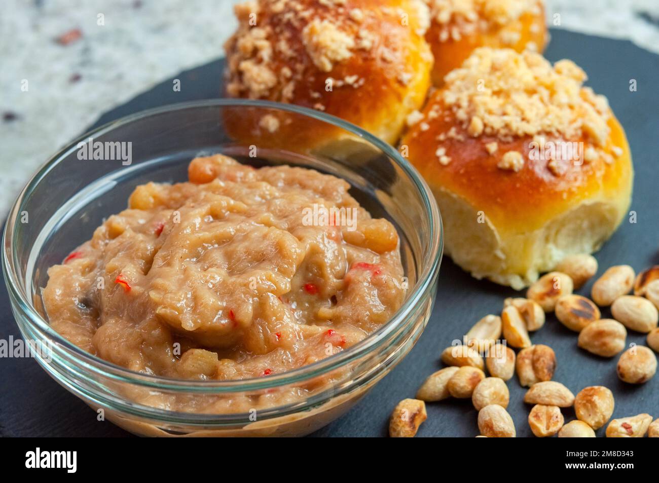 Eine Schüssel Apfelchutney mit Brötchen und Erdnuss. Hausgemachtes Apfelchutney. Makroaufnahme. Stockfoto