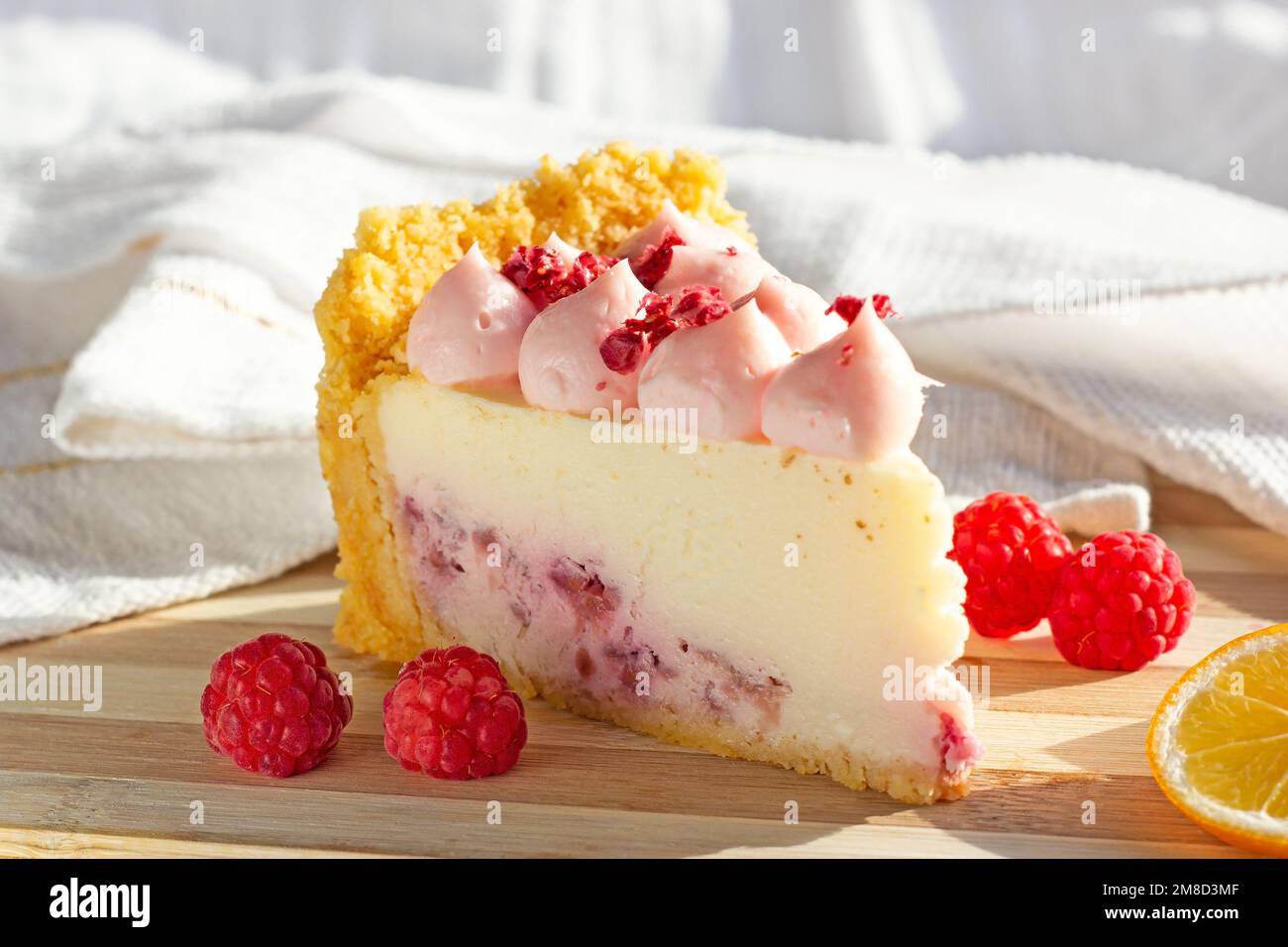 Köstliche weiße und rosafarbene süße Himbeer Käsekuchen mit frischen Beeren auf dem Holzbrett in der Küche. Stockfoto