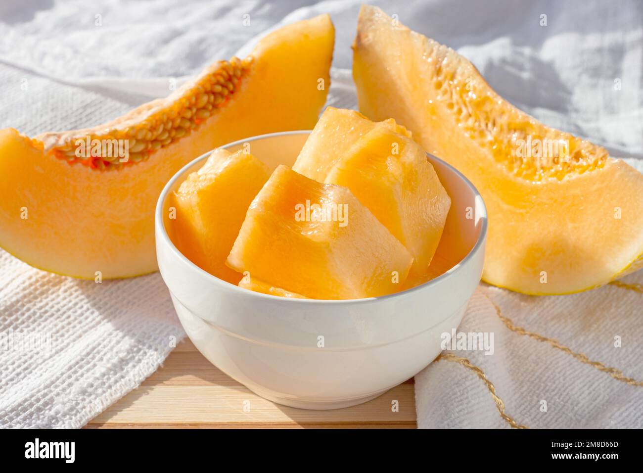 Frische süße, saftige Honigmelone (Cantaloupe) in Scheiben in einer weißen Schüssel in der Küche im Sommer. Stockfoto