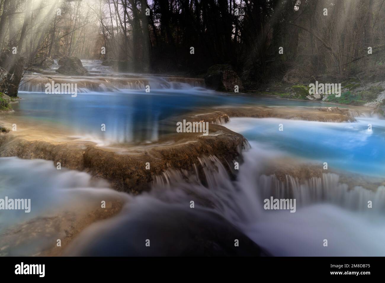 Eine Reihe toskanischer Wasserfälle, die vom elsa mit Nebel und Sonnenbalken erzeugt werden Stockfoto