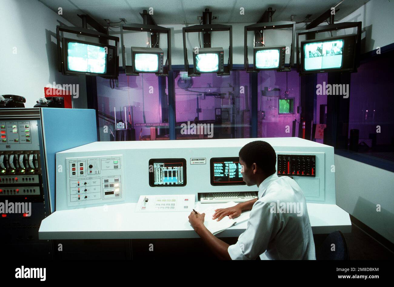 Jim Crump, ein ziviler Techniker, erfasst einige Daten von einem der Monitore im Reaktorkontrollraum. Stützpunkt: Luftwaffenstützpunkt McClellan Bundesstaat: Kalifornien (CA) Land: Vereinigte Staaten von Amerika (USA) Stockfoto