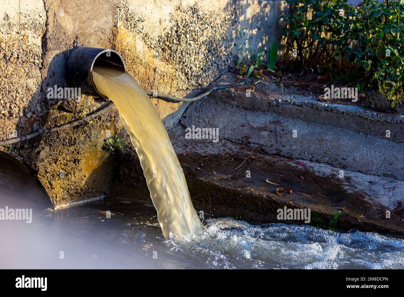 Die Abwasserabwasserleitung pumpt das verschmutzte Wasser in den Fluss. Wasserverschmutzung, Umweltkontaminationskonzept. Stockfoto