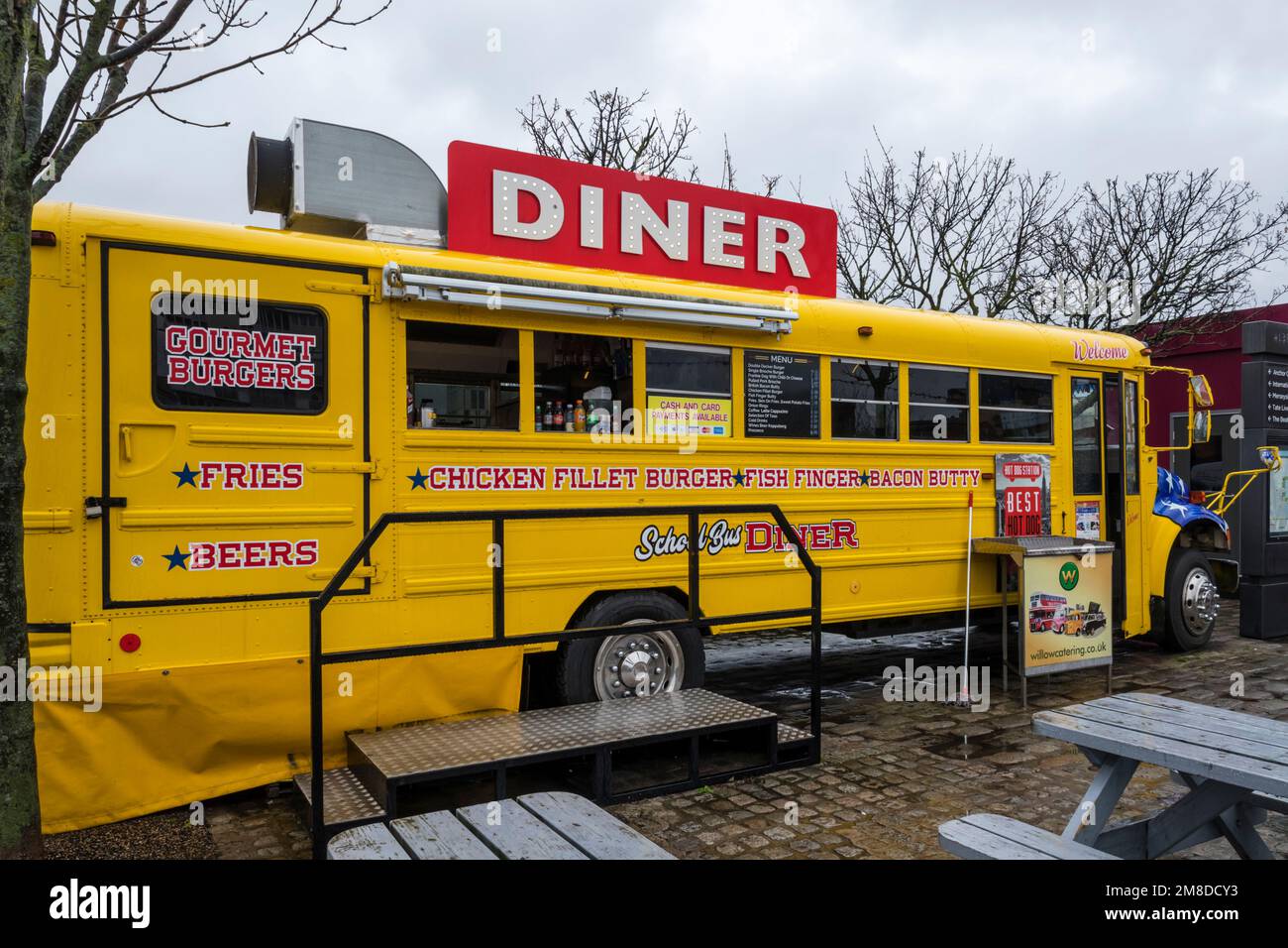 Der gelbe Schulbus wurde als Street Food Diner am Albert Dock in Liverpool umfunktioniert. Stockfoto