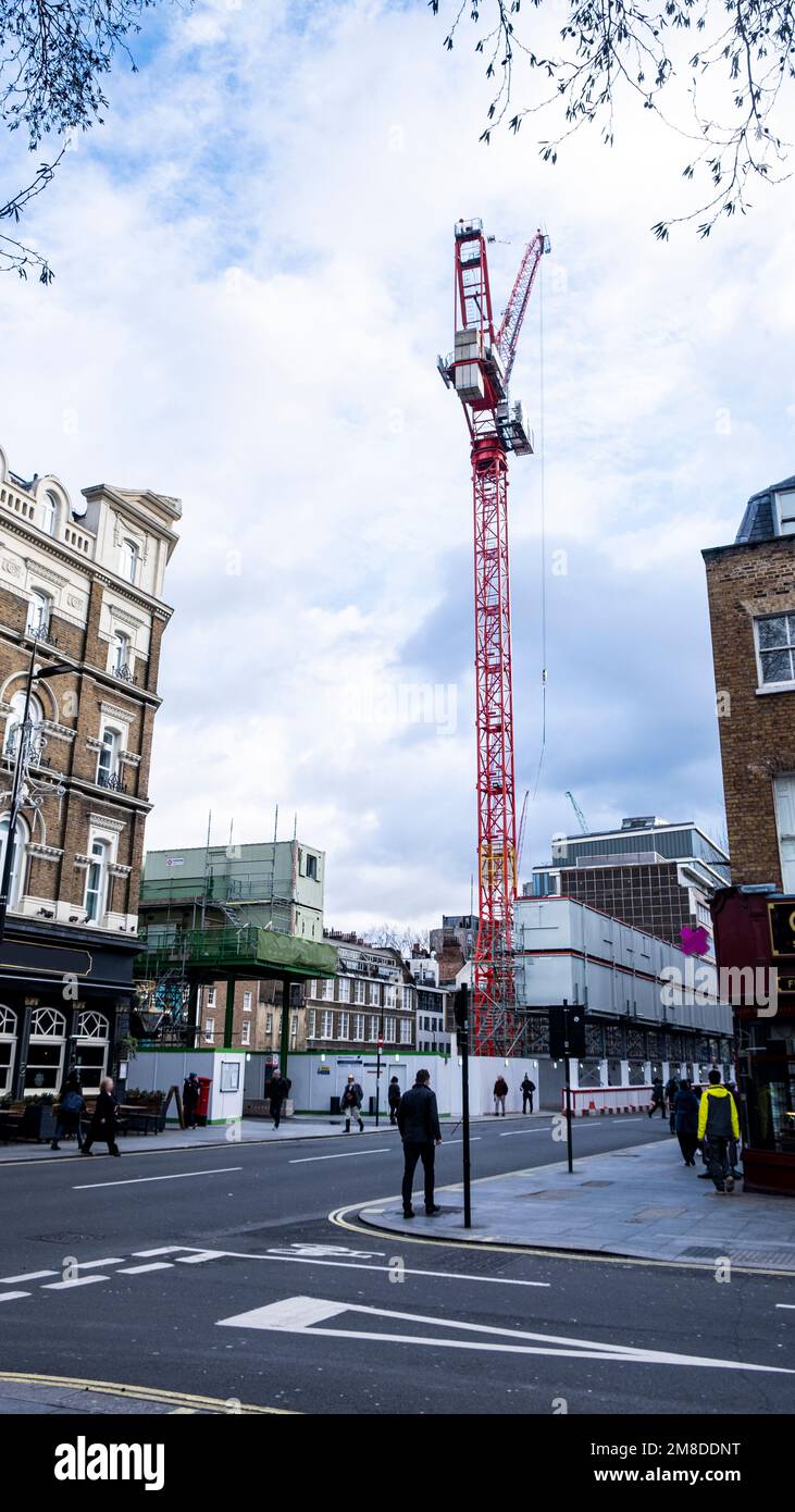 Ein extrem hoher Crake Derrick auf einem Gelände im Zentrum von London mit Hauptstraße und Fußgängern Stockfoto