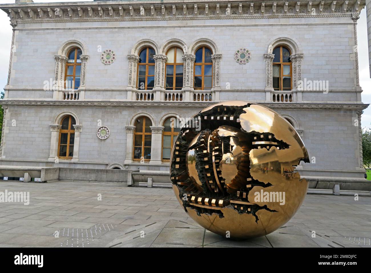 Kugel in der Kugel, spektakuläre Bronze-Globe-Kunstwerke 1982 Geschenk des Bildhauers Arnaldo Pomodoro an das Trinity College, außerhalb der Hauptbibliothek, Dublin, Irland Stockfoto