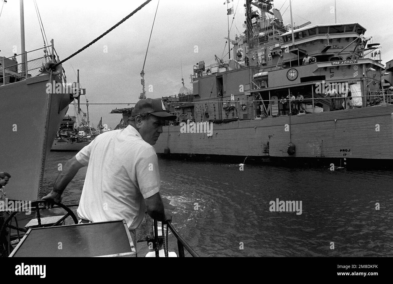 Ein Besatzungsmitglied manövriert ein Arbeitsboot in der Nähe des Mine-Gegenschiffs USS AVENGER (CMC-1), das sich neben dem Ozean-Minenräumer USS ADROIT (MSO-509) auf dem Unterwasserdeck des niederländischen Schwerhubschiffs SUPER SERVANT 3 befindet. Der SUPERDIENER 3 transportiert die Schiffe zusammen mit anderen Minenräumern in den Persischen Golf als Reaktion auf die irakische Invasion Kuwaits. Betreff Operation/Serie: WÜSTENSCHILD WÜSTENSTURM Stützpunkt: Marineflugstation, Norfolk Bundesstaat: Virginia (VA) Land: Vereinigte Staaten von Amerika (USA) Stockfoto