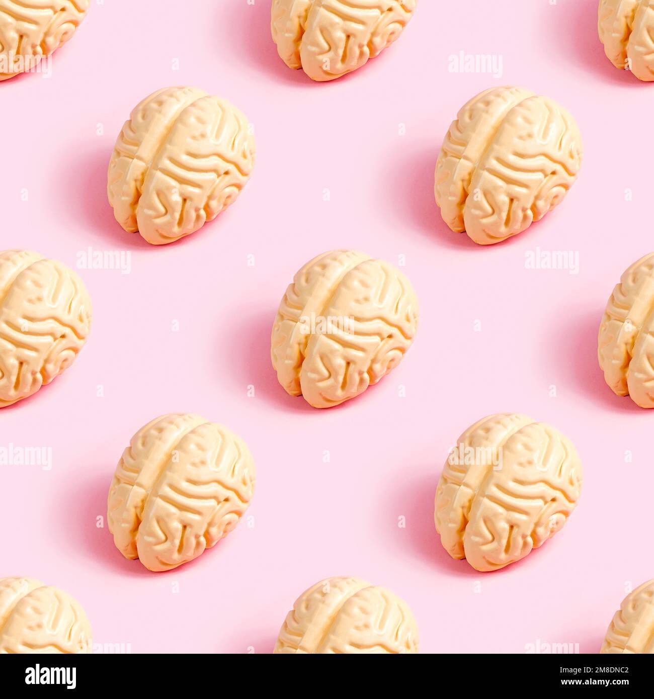 Das pinkfarbene menschliche Gehirn wiederholt ein nahtloses Muster auf pastellfarbenem Hintergrund. Kreatives Verpackungsdesign-Konzept. Stockfoto