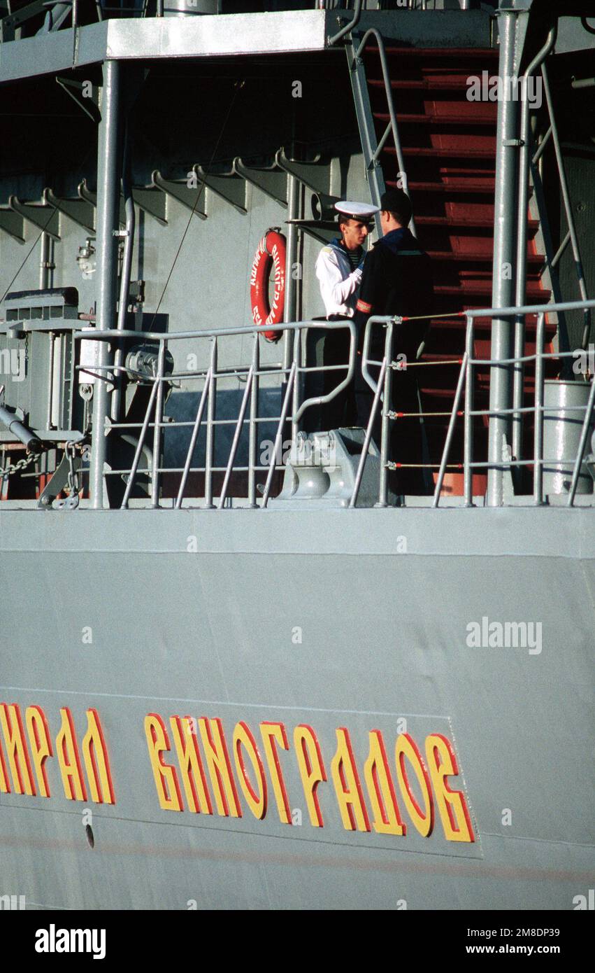 Ein sowjetischer Seemann passt die Uniform eines anderen an, während er bei einem Besuch zweier amerikanischer Kriegsschiffe in der Nähe des Hecks des Udaloy-Raketenzerstörers ADMIRAL VINGRADOV steht. Der Guided Missile Cruiser USS PRINCETON (CG 59) und die Guided Missile Freggate USS REUBEN JAMES (FFG 57) befinden sich im Rahmen eines US-sowjetischen Kulanzaustauschprogramms in Wladivostock. Basis: Wladiwostok Staat: Sibirien Land: UdSSR (SONNE) Stockfoto