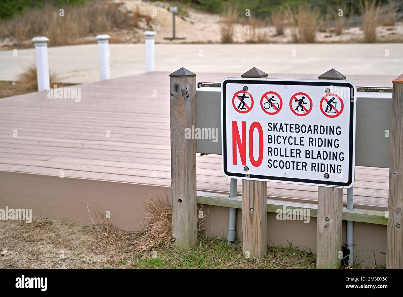 Ein Schild informiert die Öffentlichkeit darüber, dass Skateboarden, Fahrradfahren, Rollschuhfahren oder Rollerfahren verboten sind. Stockfoto