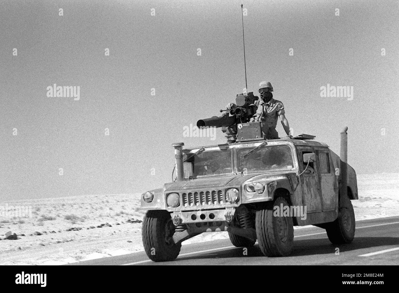 Ein Marine steht hinter der ABSCHLEPPROHRE TOW-2, die auf dem Dach eines M998 High-Mobility Multipurpose Wheeled Vehicle (HMMWV) auf einer Straße während der Operation Desert Shield eine optisch gefahrene, drahtgeführte Panzerabwehrwaffe abgibt. Betreff Operation/Serie: WÜSTENSCHILD Land: Saudi-Arabien (Sau) Stockfoto