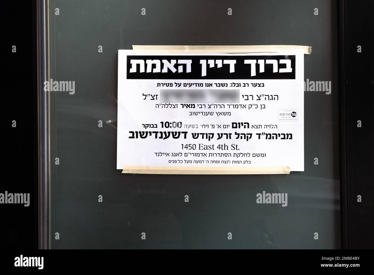 Ein jiddisches und hebräisches Schild vor einer Synagoge, das den Tod eines Gläubigen ankündigt. Es beinhaltet einen Segen für Gott. In New York City Stockfoto