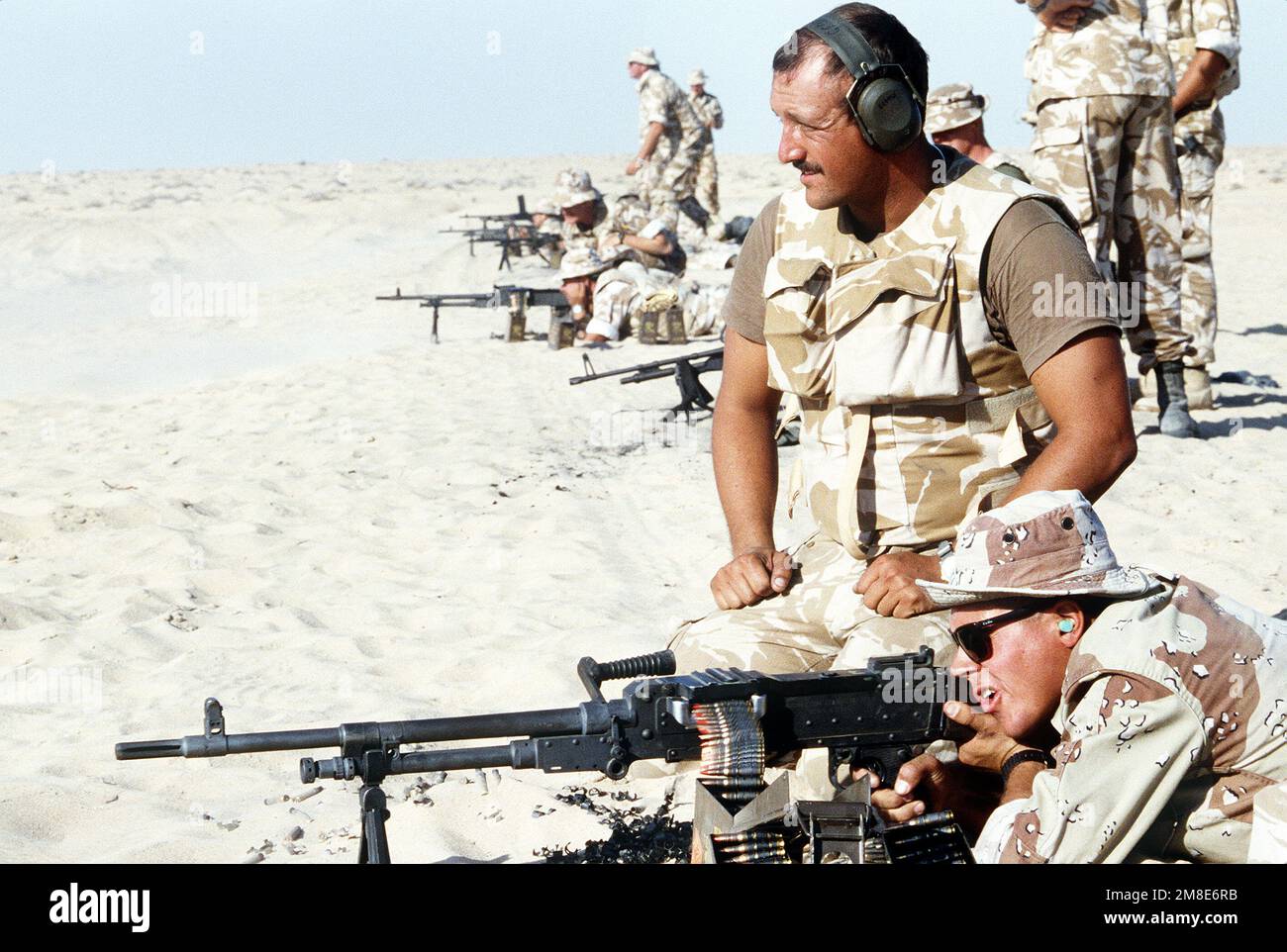 Ein britischer Soldat der Queen's Dragoon Guards beobachtet, wie ein Marine vom 7. Zug, 1. Force Reconnaissance Company, während der Operation Desert Shield ein britisches L7A2-Mehrzweck-Maschinengewehr abfeuert. Betreff Operation/Serie: WÜSTENSCHILD Land: Saudi-Arabien (Sau) Stockfoto