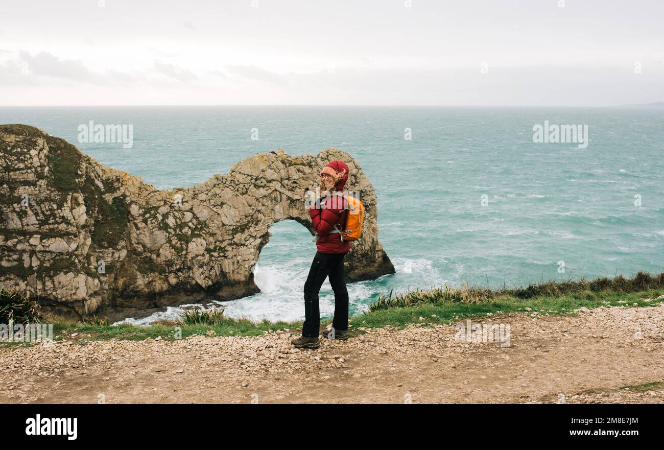 Eine Frau stand bei Durdle Door an der Jurassic Coast in England Stockfoto