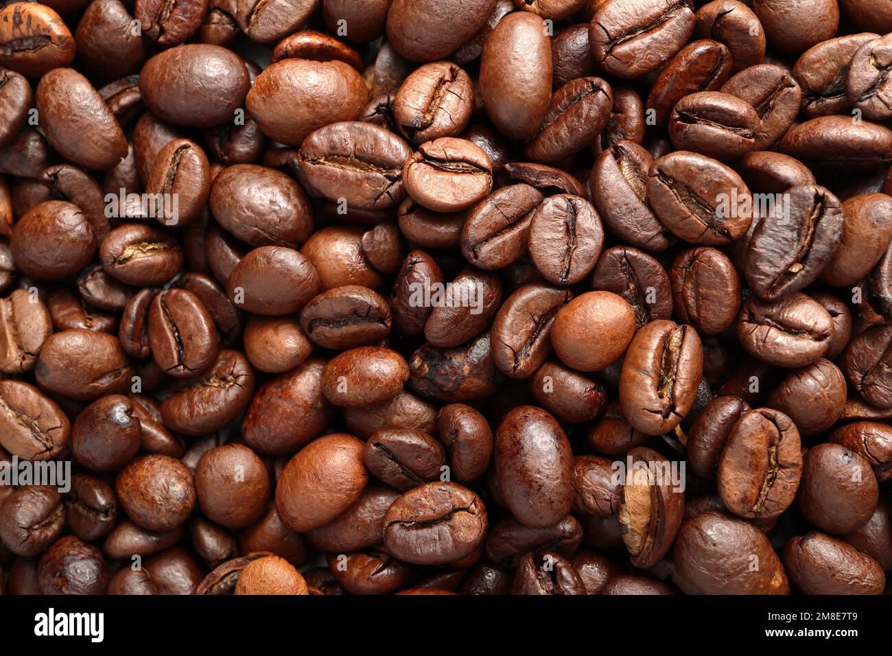 Nahaufnahme der Kaffeebohnen, die auf einer Ebenen Oberfläche liegen. Das Foto zeigt die feinen Details und die Textur des Produkts und kann als verwendet werden Stockfoto