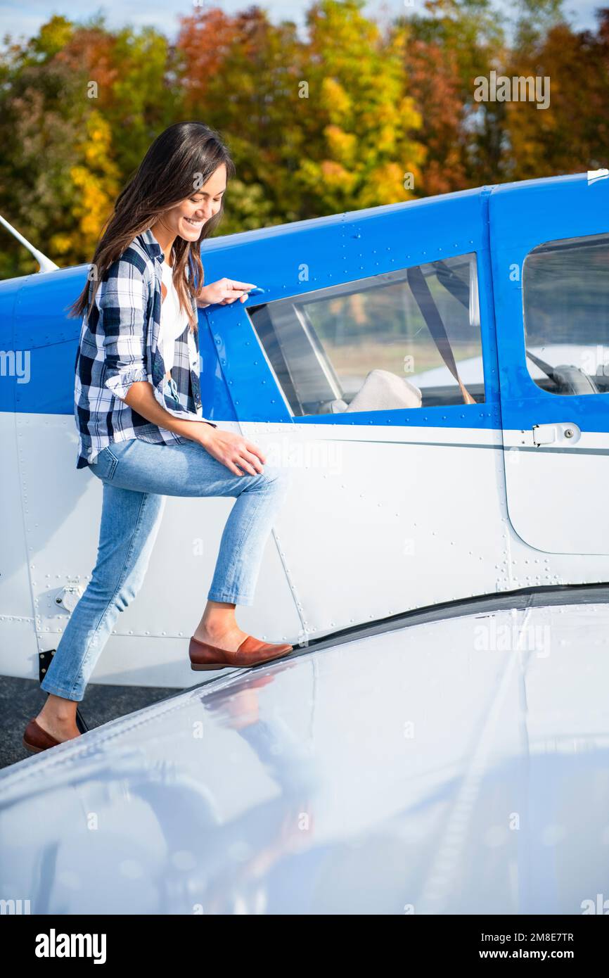 Junge BIPOC weibliche Pilotin bereitet sich auf die Reise mit einem kleinen Flugzeug vor Stockfoto