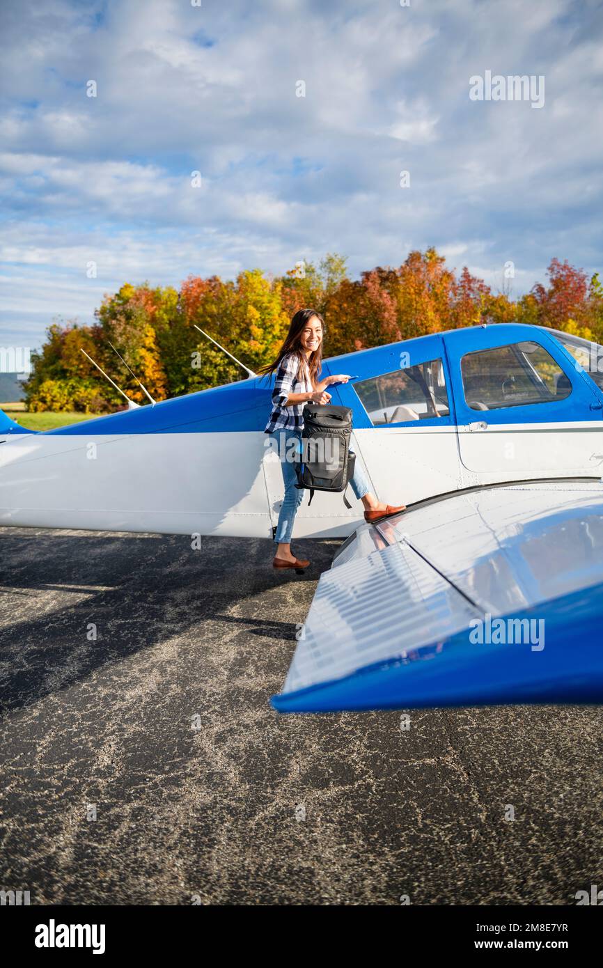 Junge BIPOC weibliche Pilotin bereitet sich auf die Reise mit einem kleinen Flugzeug vor Stockfoto