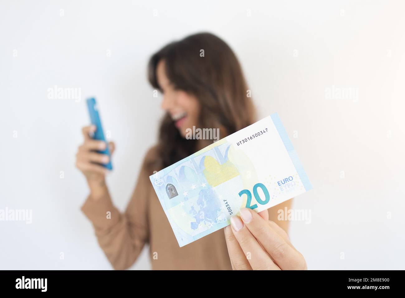 Verdienen Sie Geld Online Frau mit Smartphone und Bargeld Euro Bill Stockfoto
