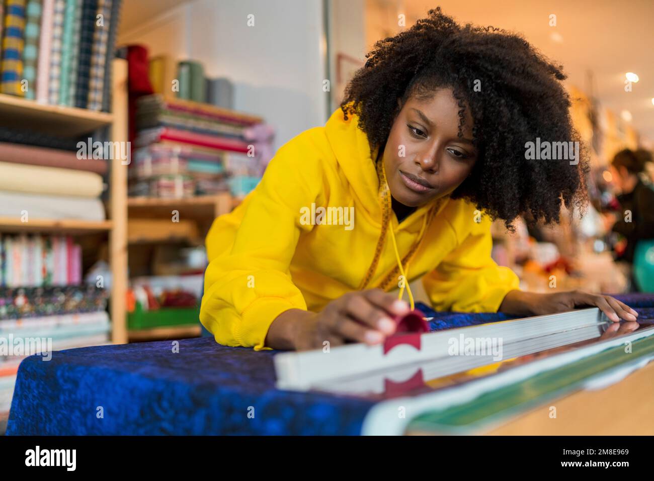 Ein afroamerikanisches Mädchen in ihrer Nähwerkstatt. Stockfoto