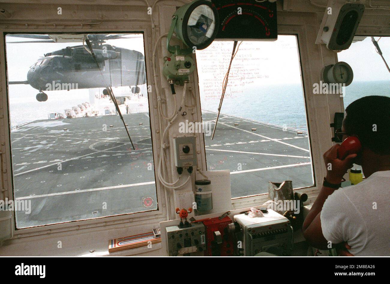 Ein Fluglotse kommuniziert mit dem Piloten eines Helicopter Combat Support Squadron 1 (HC-1) CH-53E Super-Hallion-Hubschraubers, wenn er vom Cockpit des Krankenhausschiffs USNS COMFORT (T-AH-20) startet. Der KOMFORT wird während der Operation Desert Storm am Persischen Golf eingesetzt. Betroffene Operation/Serie: WÜSTENSTURM Land: Unbekannt Stockfoto