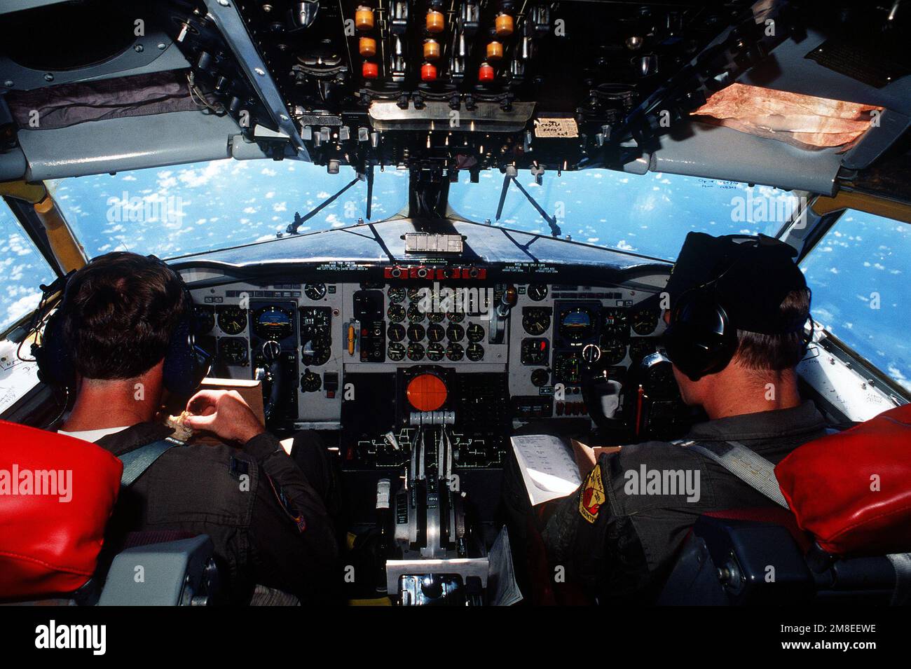 HAUPTMANN. James Herrin, Pilot und LT. Jason Walls, Kopilot, essen Mittagessen an Bord ihres KC-135A Stratotanker-Flugzeugs auf dem Weg zum Anderson Air Force Base, Guam. Das Flugzeug wird später nach Saudi-Arabien fliegen, um an Operation Desert Shield teilzunehmen. Herrin und Walls sind Mitglieder der 924. Luftauftankschwadron. Betroffene Operation/Serie: WÜSTENSCHILD Land: Unbekannt Stockfoto