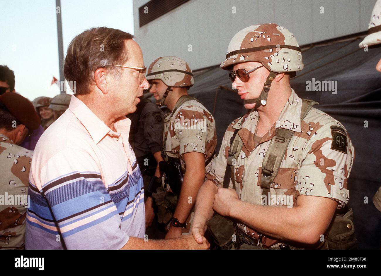 Sen. Sam Nunn aus Georgia begrüßt ein Mitglied der 82. Luftwaffendivision während der Operation Desert Shield auf einer Tour durch eine militärische Einrichtung. Betreff Operation/Serie: WÜSTENSCHILD Land: Saudi-Arabien (Sau) Stockfoto