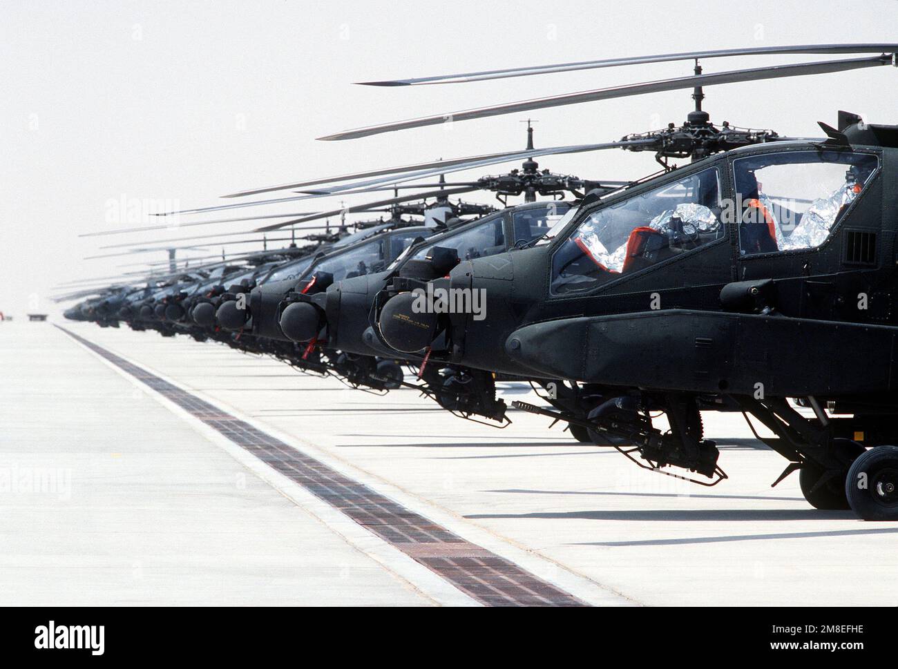 Mehrere AH-64A Apache Hubschrauber sitzen während der Operation Desert Shield untätig auf der Fluglinie. Betreff Operation/Serie: WÜSTENSCHILD Land: Saudi-Arabien (Sau) Stockfoto