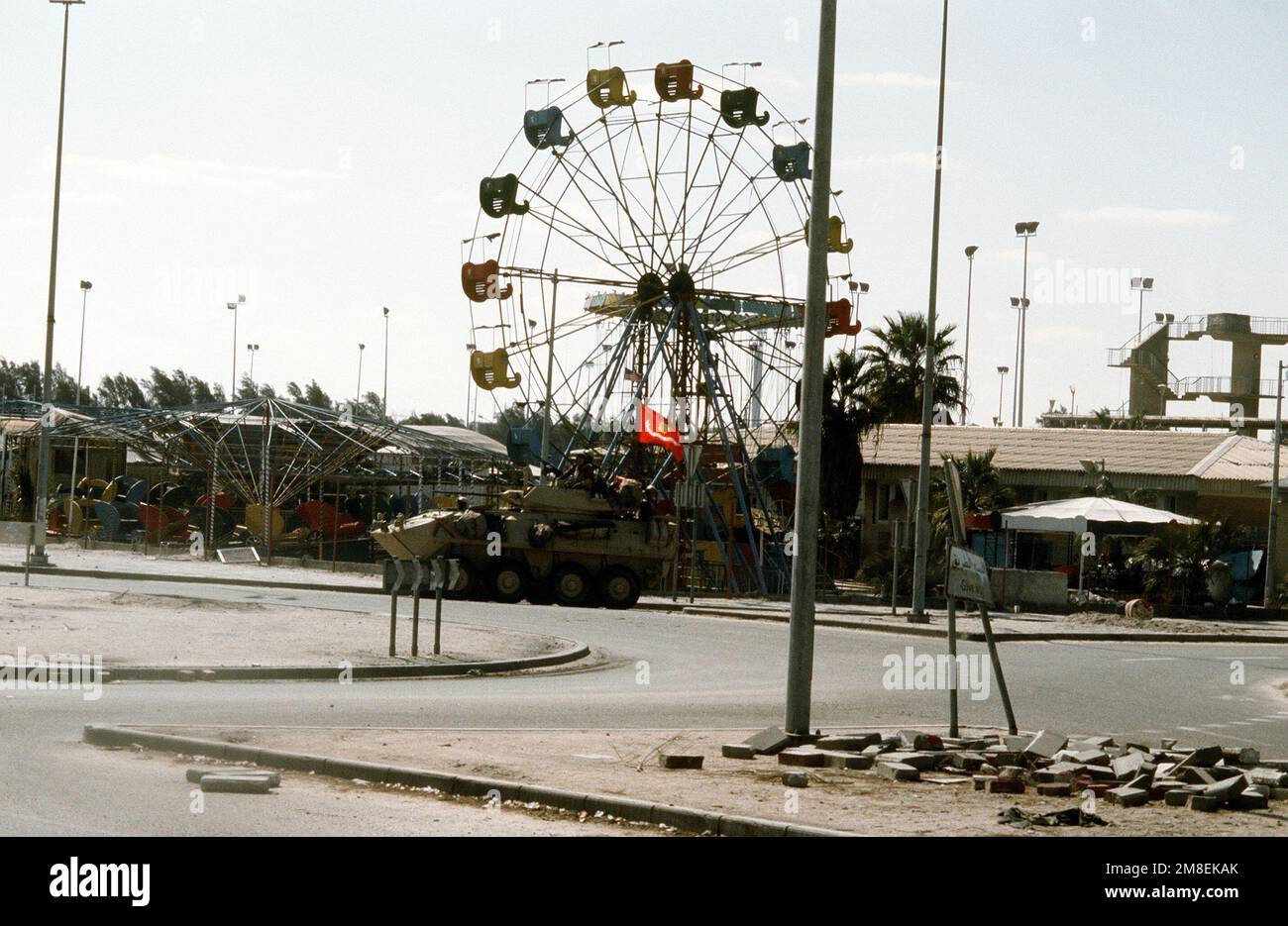 Ein leichtes gepanzertes Marine Corps LAV-25-Fahrzeug fährt während der Operation Desert Storm an einem kuwaitischen Vergnügungspark vorbei. Betreff Betrieb/Serie: WÜSTENSTURMLAND: Kuwait (KWT) Stockfoto