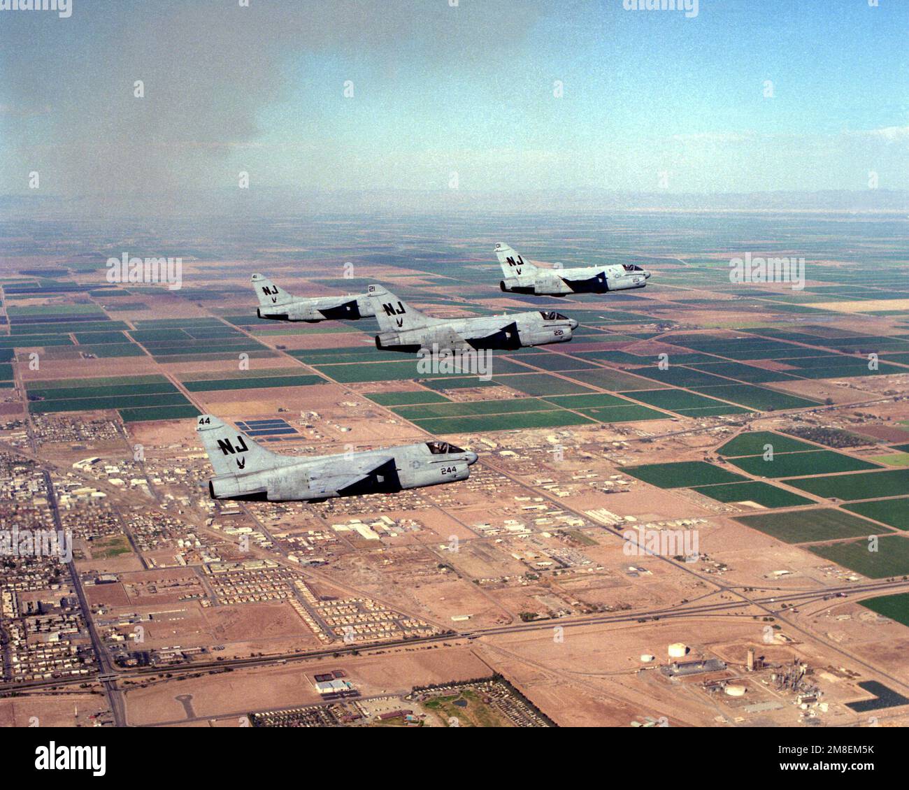 Vier A-7E Corsair-Flugzeuge von Angriffsschwadron 122 (VA-122) fliegen während einer Ausbildungsmission in Formation über der Stadt. VA-122, das letzte A-7-Flottenersatzgeschwader der Navy, wird am 31. Mai 1991 aufgelöst. Basis: Naval Air Facility, El Centro Bundesstaat: Kalifornien(CA) Land: Vereinigte Staaten von Amerika(USA) Stockfoto