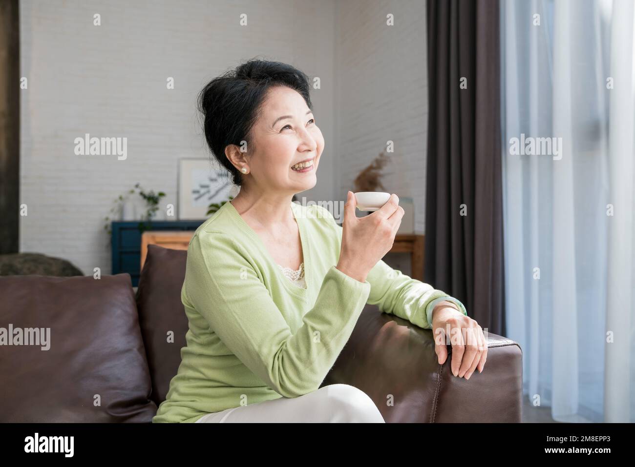 Eine ältere Frau in einer Tasse Tee Stockfoto