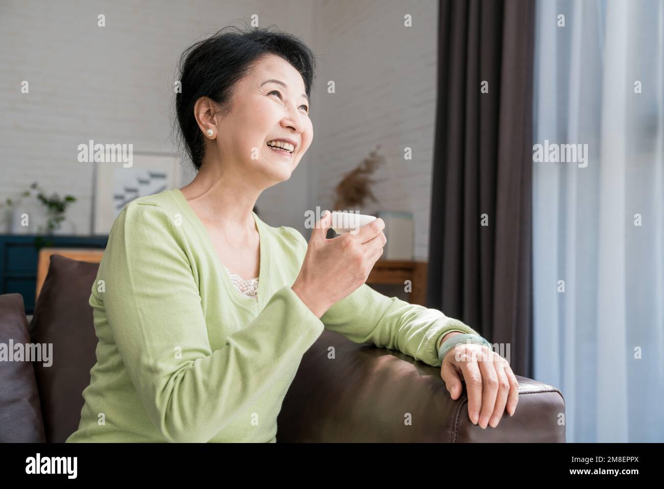 Eine ältere Frau in einer Tasse Tee Stockfoto