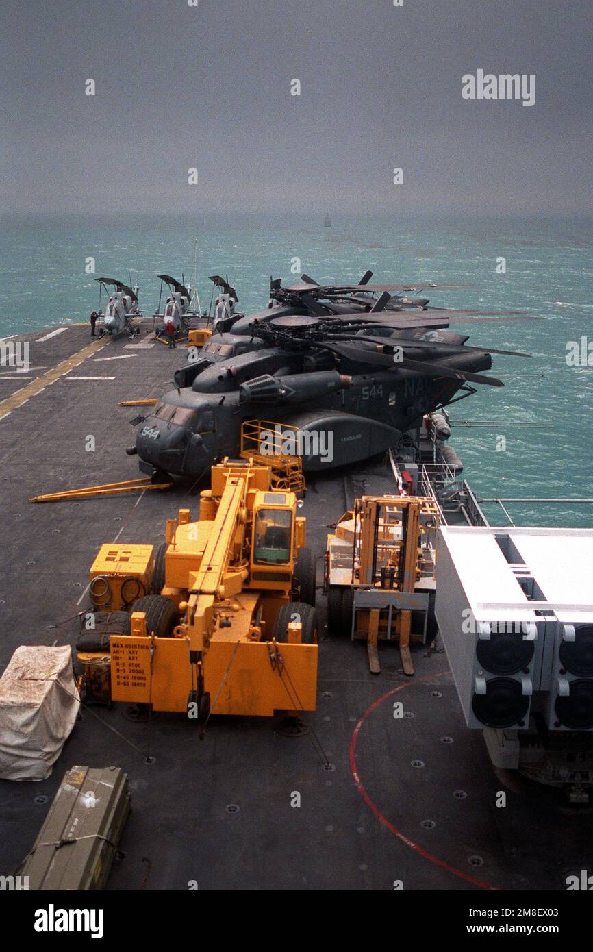 Zwei Helicopter Mine Gegenmaßnahmen Staffel 14 (HM-14) MH-53E Sea Dragon Hubschrauber, Vordergrund, und mehrere Marine Corps AH-1T Sea Cobra Hubschrauber sitzen auf dem Flugdeck des Amphibienschiffs USS NEW ORLEANS (LPH-11). Das NEW ORLEANS dient als Plattform für Minenräumarbeiten im Golf nach dem Waffenstillstand, der die Operation Desert Storm beendet hat. Betroffene Operation/Serie: WÜSTENSTURM Land: Unbekannt Stockfoto