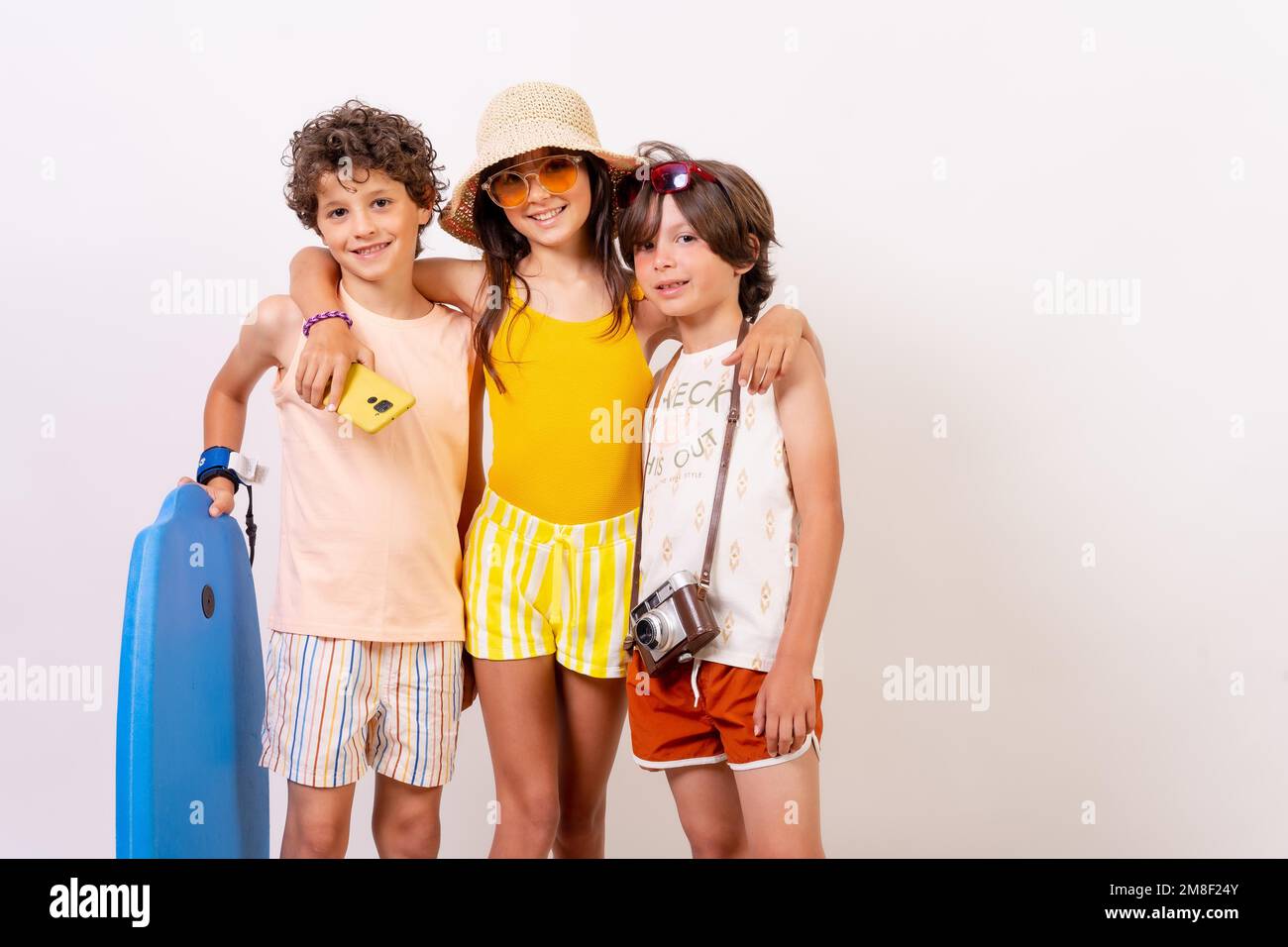 Studioaufnahme von Kindern, die im Sommerurlaub lächeln und Spaß haben, auf weißem Hintergrund Stockfoto