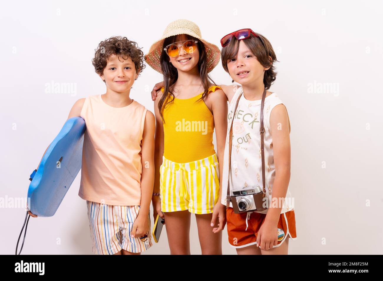 Studioaufnahme von Kindern, die im Sommerurlaub auf weißem Hintergrund lächeln Stockfoto