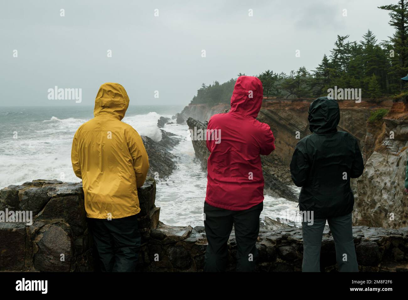 Die farbenfrohe Outdoor-Kleidung an der Küste Oregons sorgt für einen Blick auf die Wellen. Stockfoto