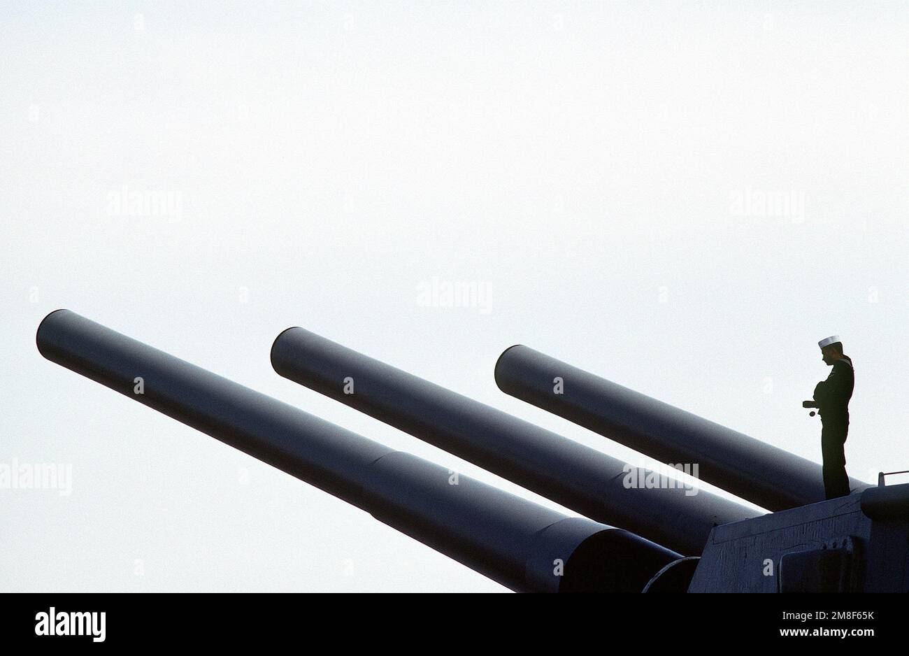 Nach der Ankunft des Schiffes im Hafen steht ein Matrose auf einem Mark 7 16-Zoll/50-Kaliber-Geschützturm an Bord des Schlachtschiff USS WISCONSIN (BB-64). WISCONSIN und andere Schiffe der USS JOHN F. KENNEDY (CV-67)-Gefechtsgruppe kehren nach Norfolk zurück, nachdem sie während der Operation Desert Storm im Persischen Golf stationiert waren. Betrifft Operation/Serie: STÜTZPUNKT WÜSTENSTURM: Marineflugstation, Norfolk Bundesstaat: Virginia (VA) Land: Vereinigte Staaten von Amerika (USA) Stockfoto